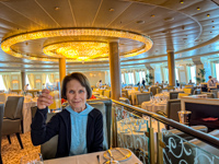 Photo from Susan's Story, Susan raising a toast in the main dining room of Oceania Marina