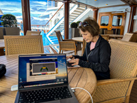 Photo from Susan's Story, Susan at work typing her travel story outside on deck 14